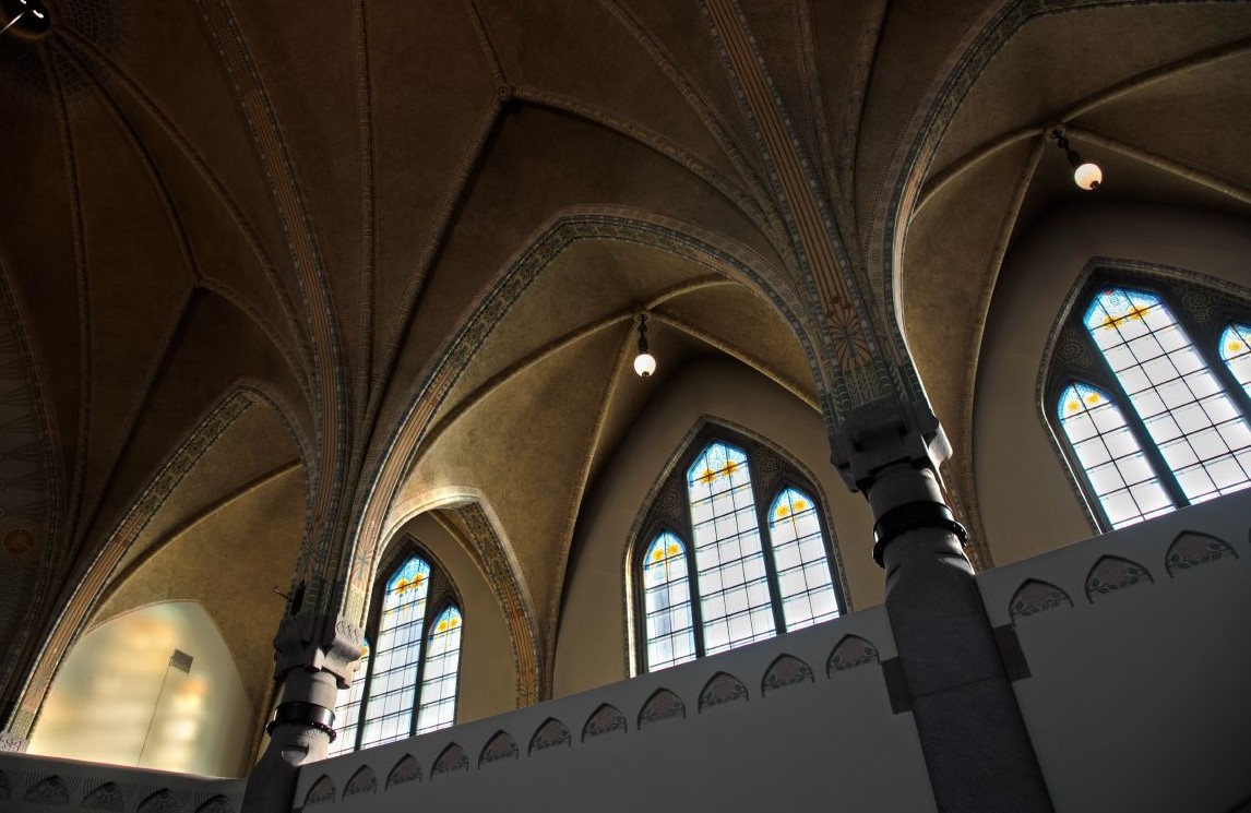 Valoa virtaa sisään vanhaan kirkkoon goottisten ikkunoiden läpi.